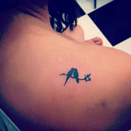 Lovebirds tattoo on back shoulder.