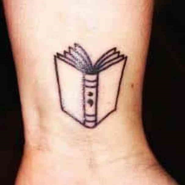 Nice book tattoo with semicolon to present do not close the book of your life.