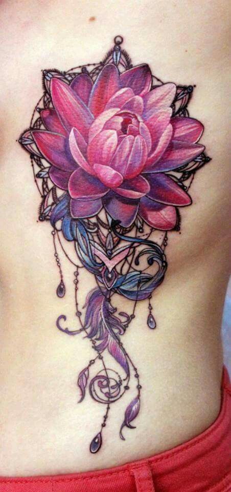 Pink and purple flower tattoo with feathers.