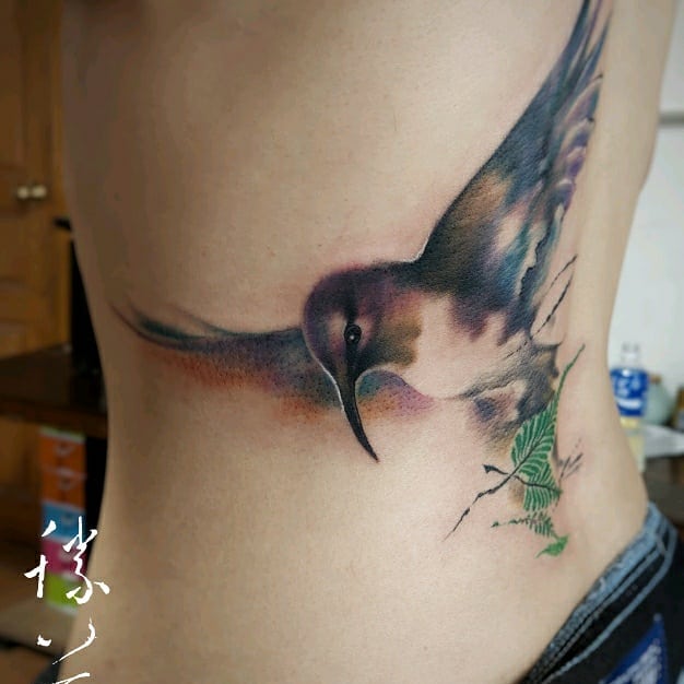 Realistic humming bird tattoo on back.