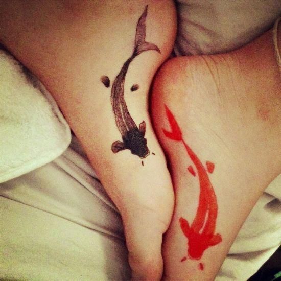 Red and black koi fish tattoos on foot.