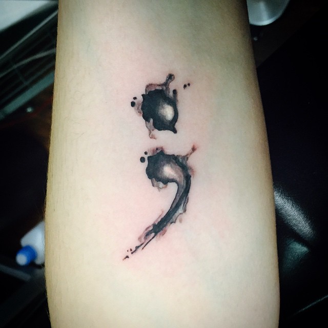 Semicolon tattoo made by ink drops.
