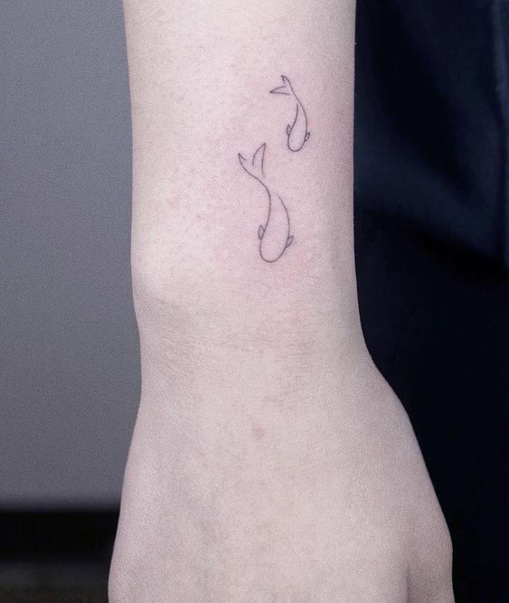 Simple fineline tattoo of fishes.