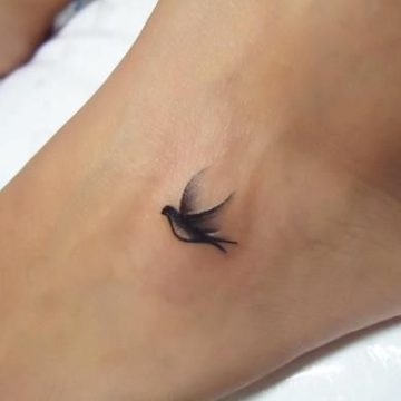 Single bird tattoo on foot.