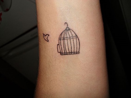 Small bird with cage inked on wrist.
