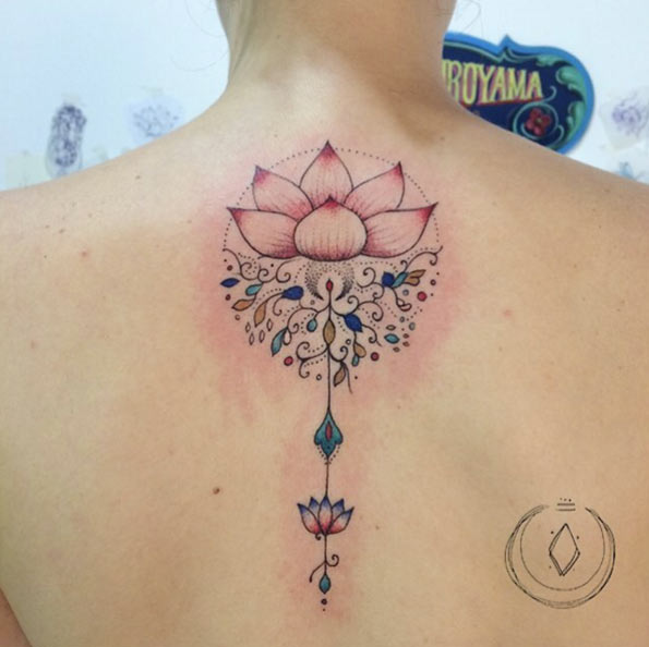 This light pink lotus flower is almost overshadowed by the ornamental designs hanging from below.