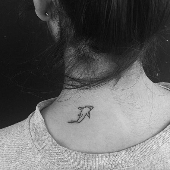 Tiny shark tattoo on the back of the neck.