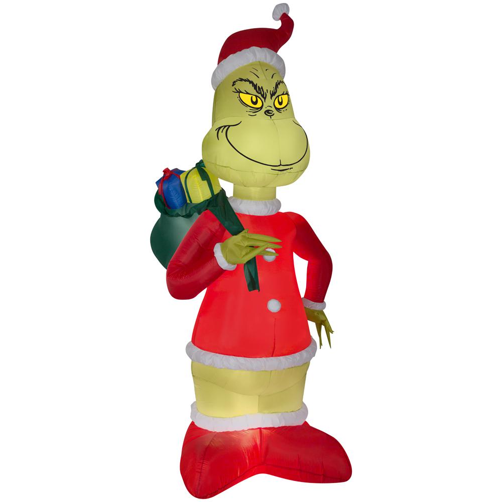 Inflatable Grinch in Santa suit for outdoor decor.