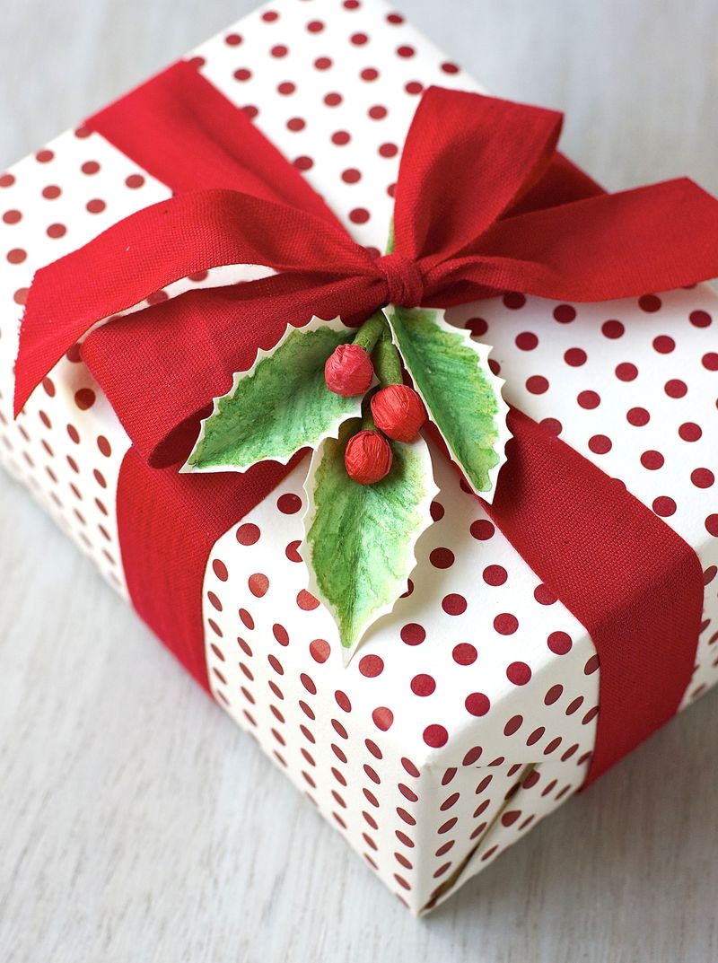 Polka dot gift wrap tie with red ribbon and painted leaves.