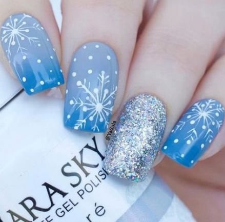 Trendy blue nails with snowflakes.