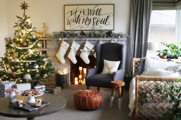 Cottage living area decoration with Christmas tree, stockings, pinecones and candles.