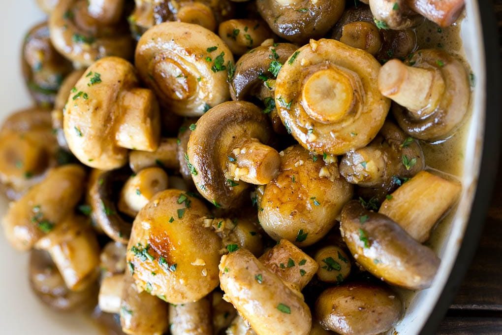 Delectable garlic mushrooms are served in butter and herb sauce.