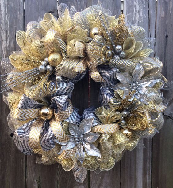 Double tone fabric wreath with large metallic poinsettias and a collection of gold and silver holiday bulbs.