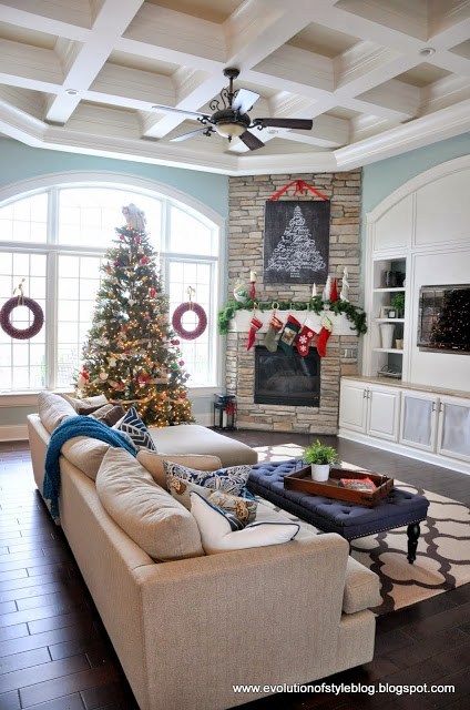 Fabulous Christmas living room decorated with wreath on windows, tree and fire place.