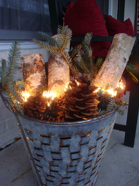 Galvanized Christmas basket filled with pinecones, ornaments & lights.