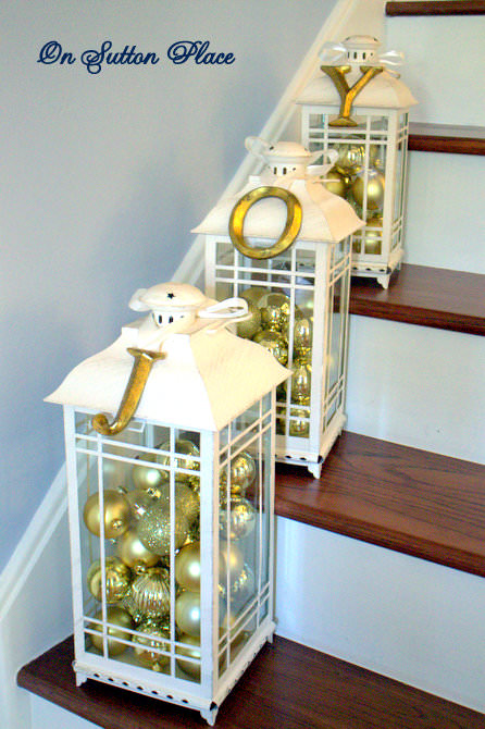Lanterns filled with golden Christmas baubles for staircase decoration.