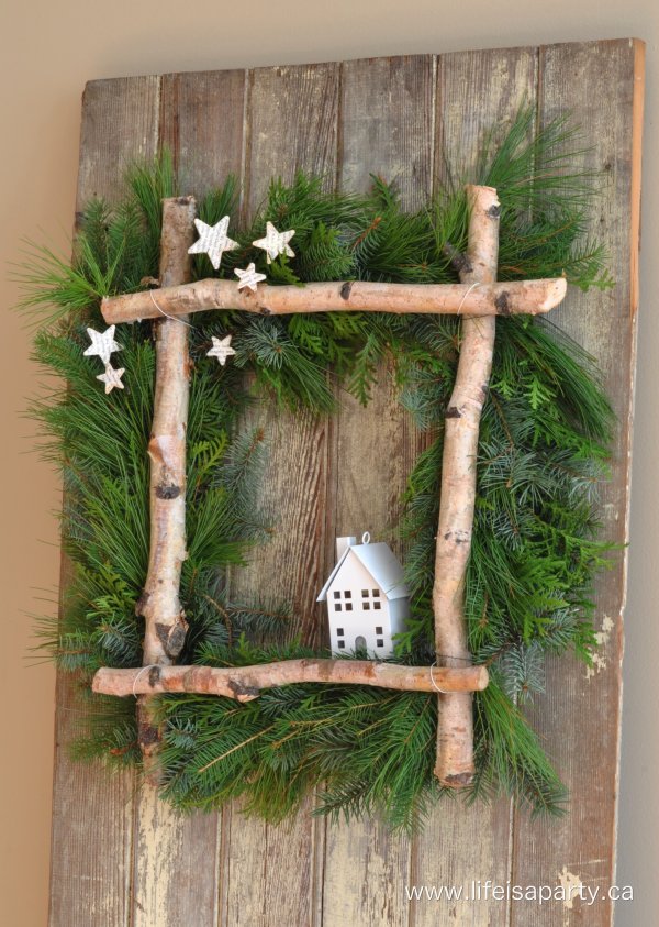 Little house in wooden frame wreath for Christmas.