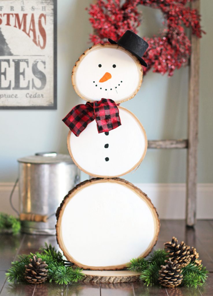 Log slice snowman with adorable at entry to welcome your guests.