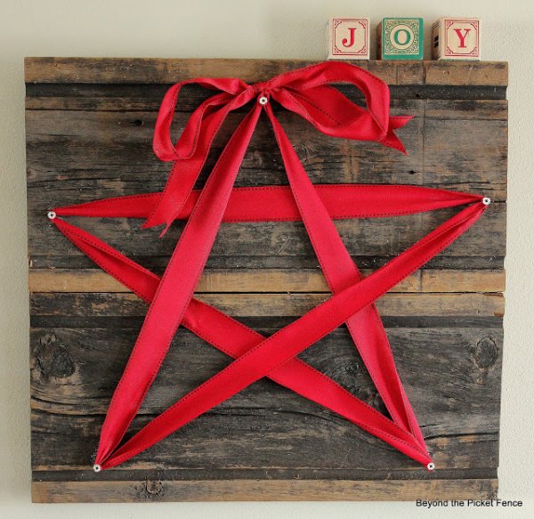 Reclaimed woooden piece decorated with ribbon as star.