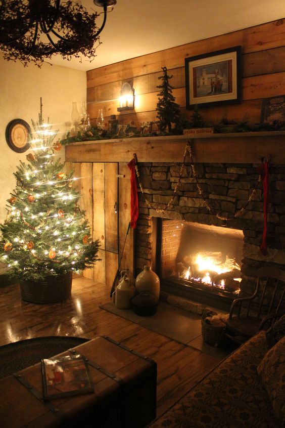 Rustic living room decoration with Christmas tree, chandelier and fireplace.