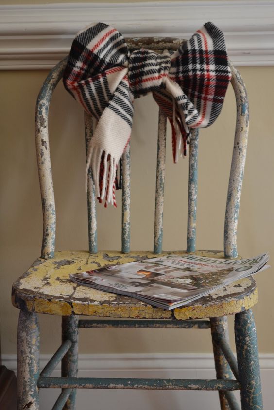 Vintage chair is decorated plaid scarf.