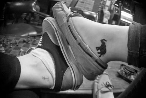 Black elephant ankle tattoo.