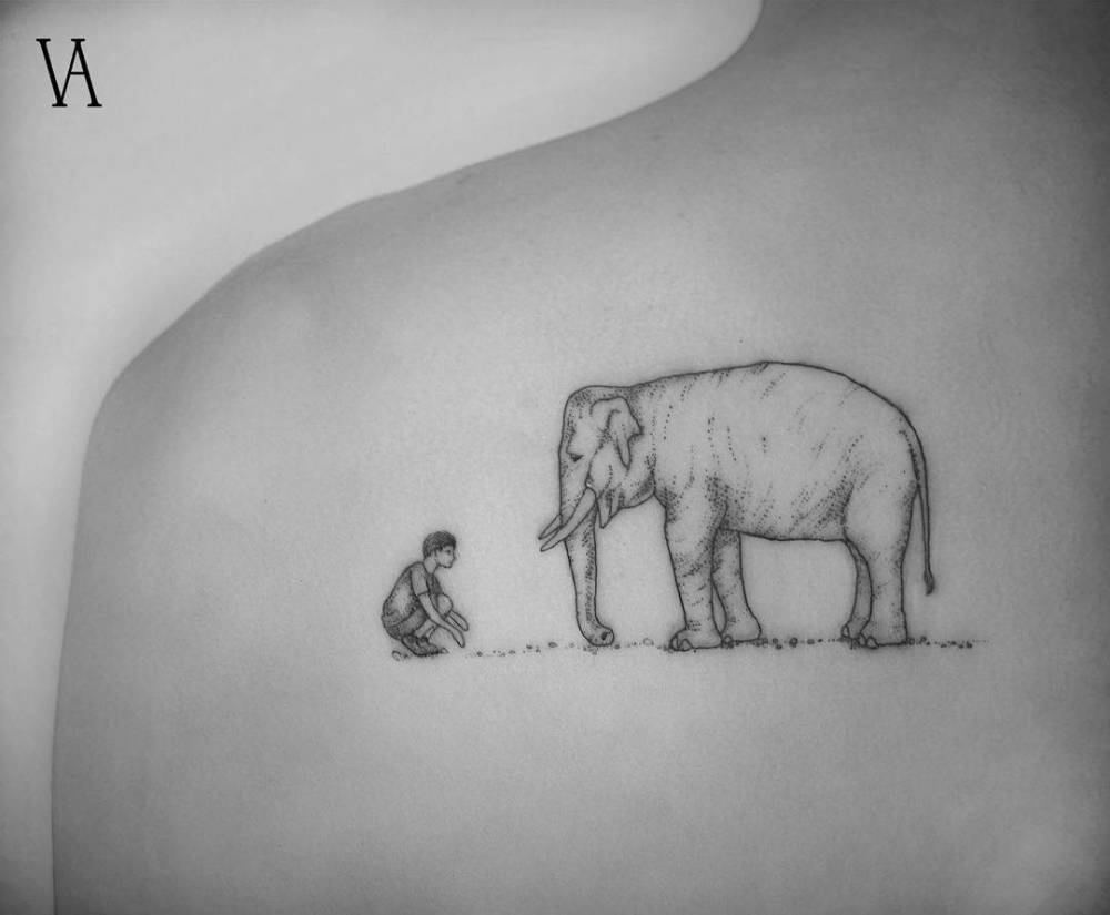 Elephant tattoo with man on shoulder.
