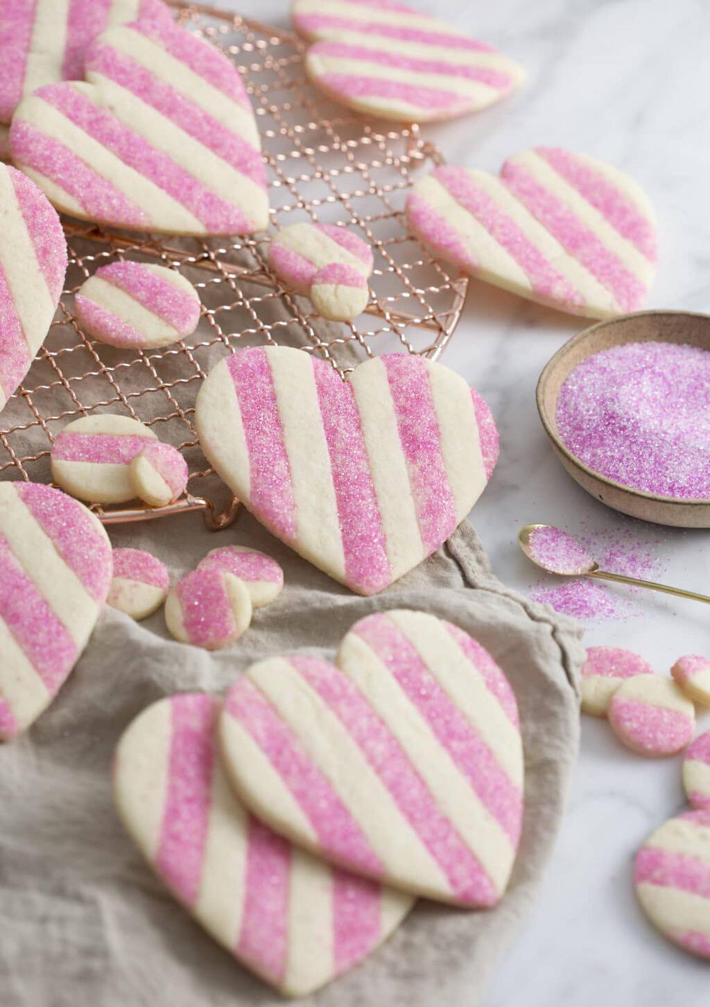 Pink and white striped heart-shaped Valentine cookies with a little extra sparkle.