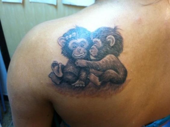 Affectionate baby monkeys on shoulder.