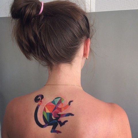 Colorful geometric monkey tattoo on back.