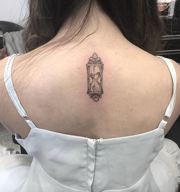 Cool hourglass tattoo on upper neck.