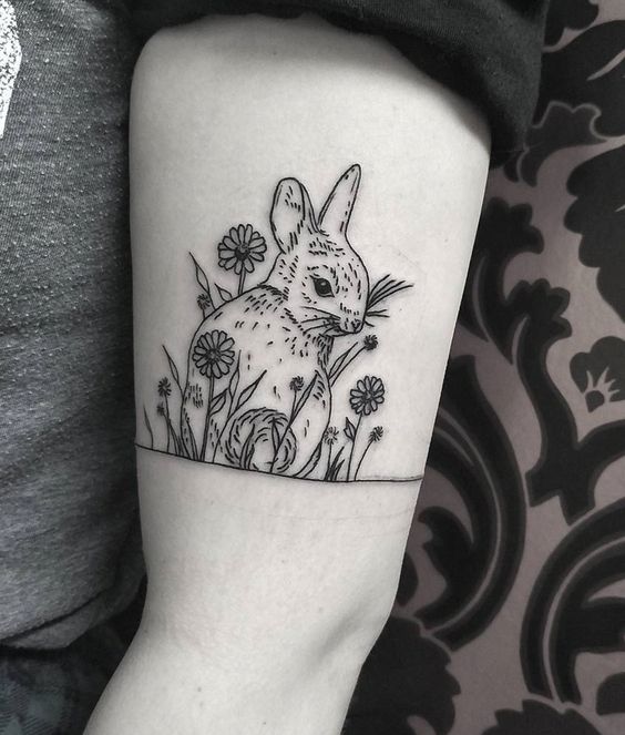 Cute bunny tattoo on upper arm.