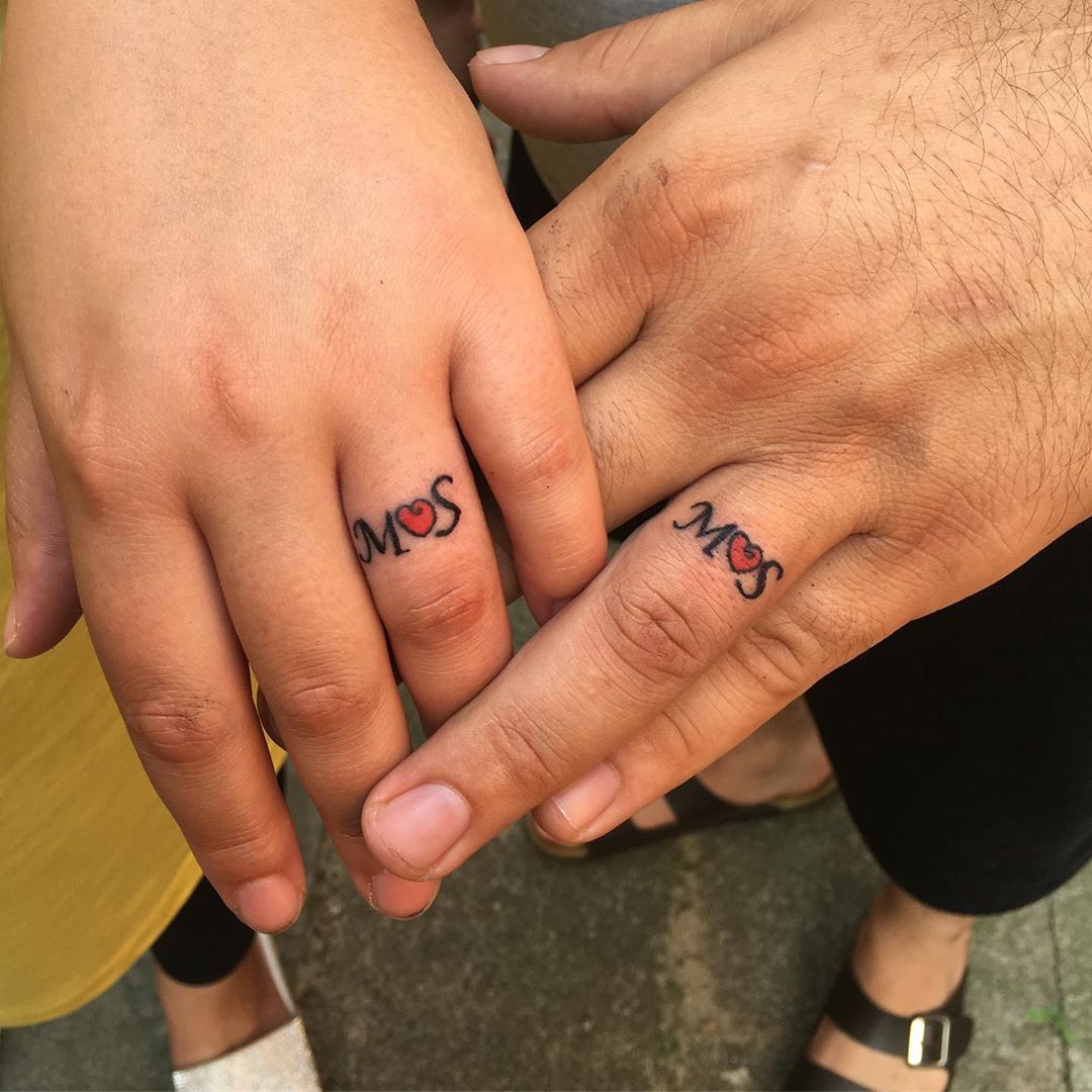 Dazzling matching tattoos connected by heart.