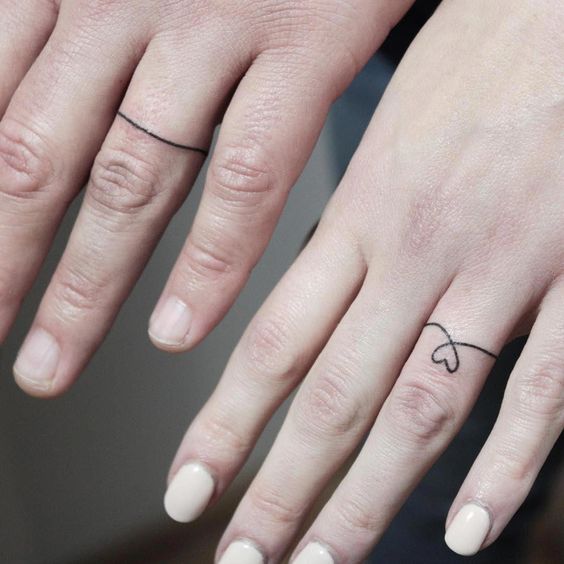 Fineline ring finger tattoo.