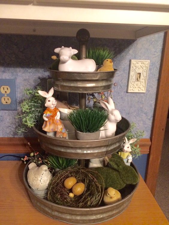 Galvanized tiered tray filled with bunnies and flowers for Easter.