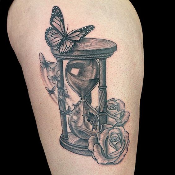 Grey hourglass tattoo with flowers and butterfly.