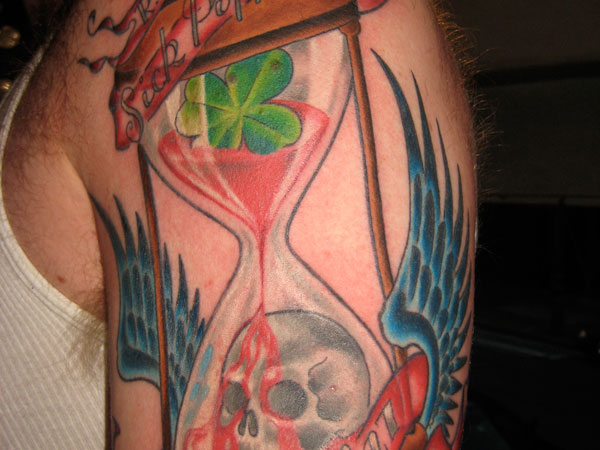 Hourglass with a skull and clover leaf.