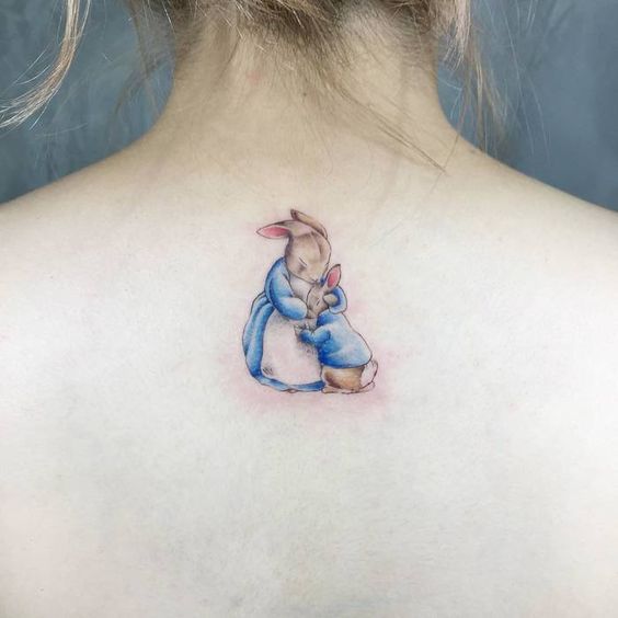 Mother and baby bunny tattoo on upper neck.