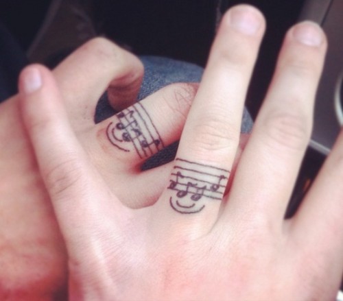 Music notes inked on ring finger.