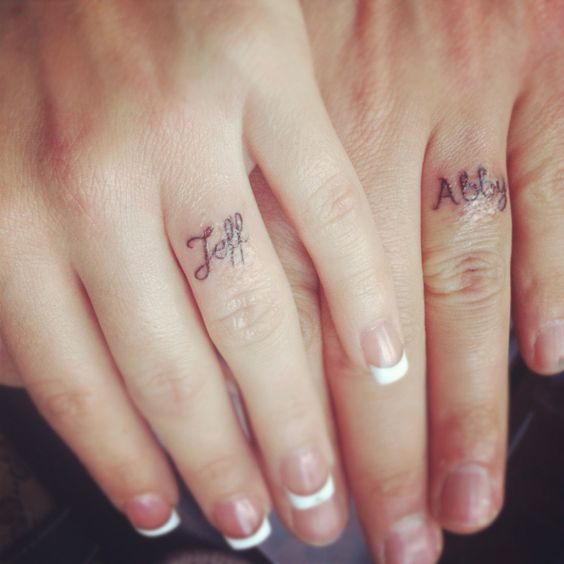 Name tattooed on ring fingers.