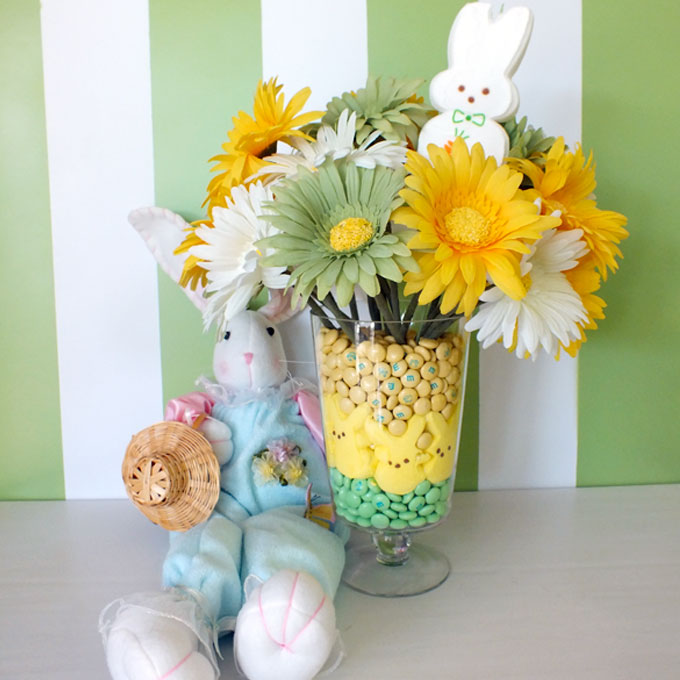 Peeps bunny candies with M & M in glass vase with flowers.