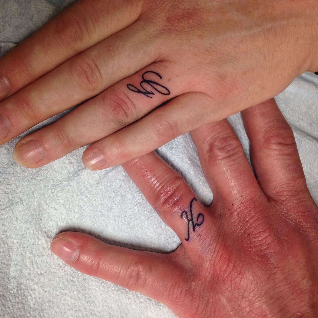 Simple but impressive initial tattoos on ring finger.