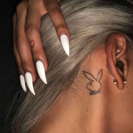 Small bunny tattoo behind the ear.
