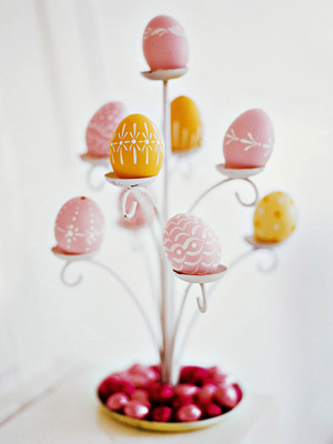 Tiered candle holder decorated with dyed eggs.