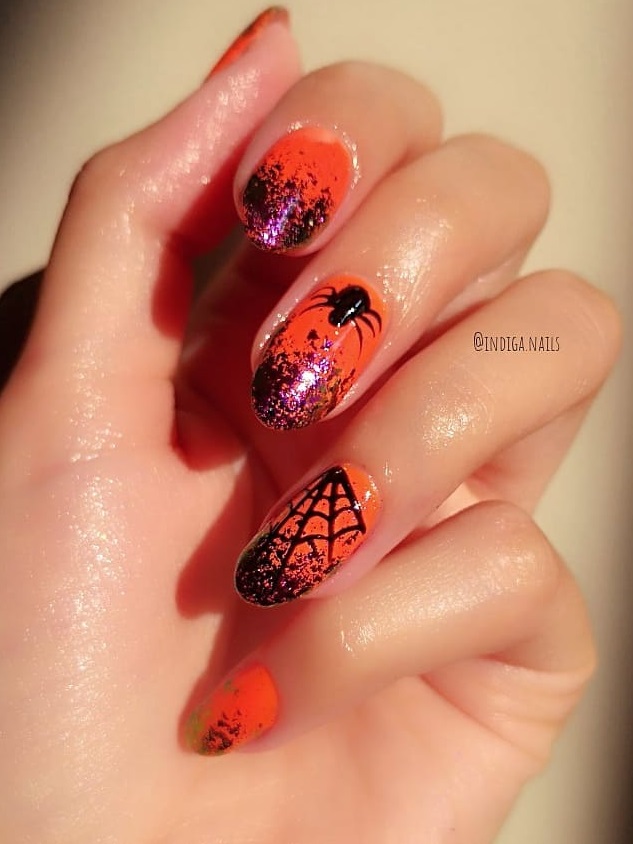 Dashing orange spider web nails. Pic by indiga.nails