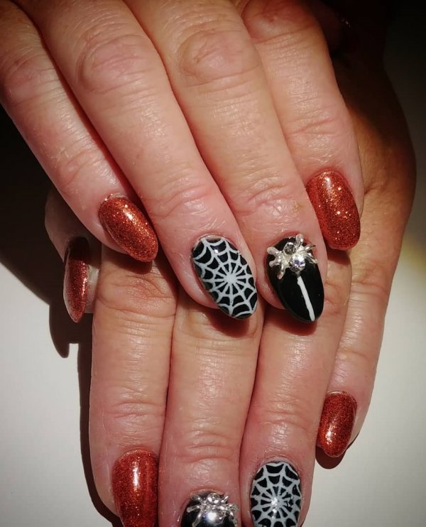 Pretty black and orange glitter spider web nails. Pic by clarabellabeautybar