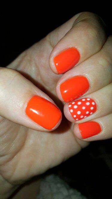 Orange gel polish, white polka dots.